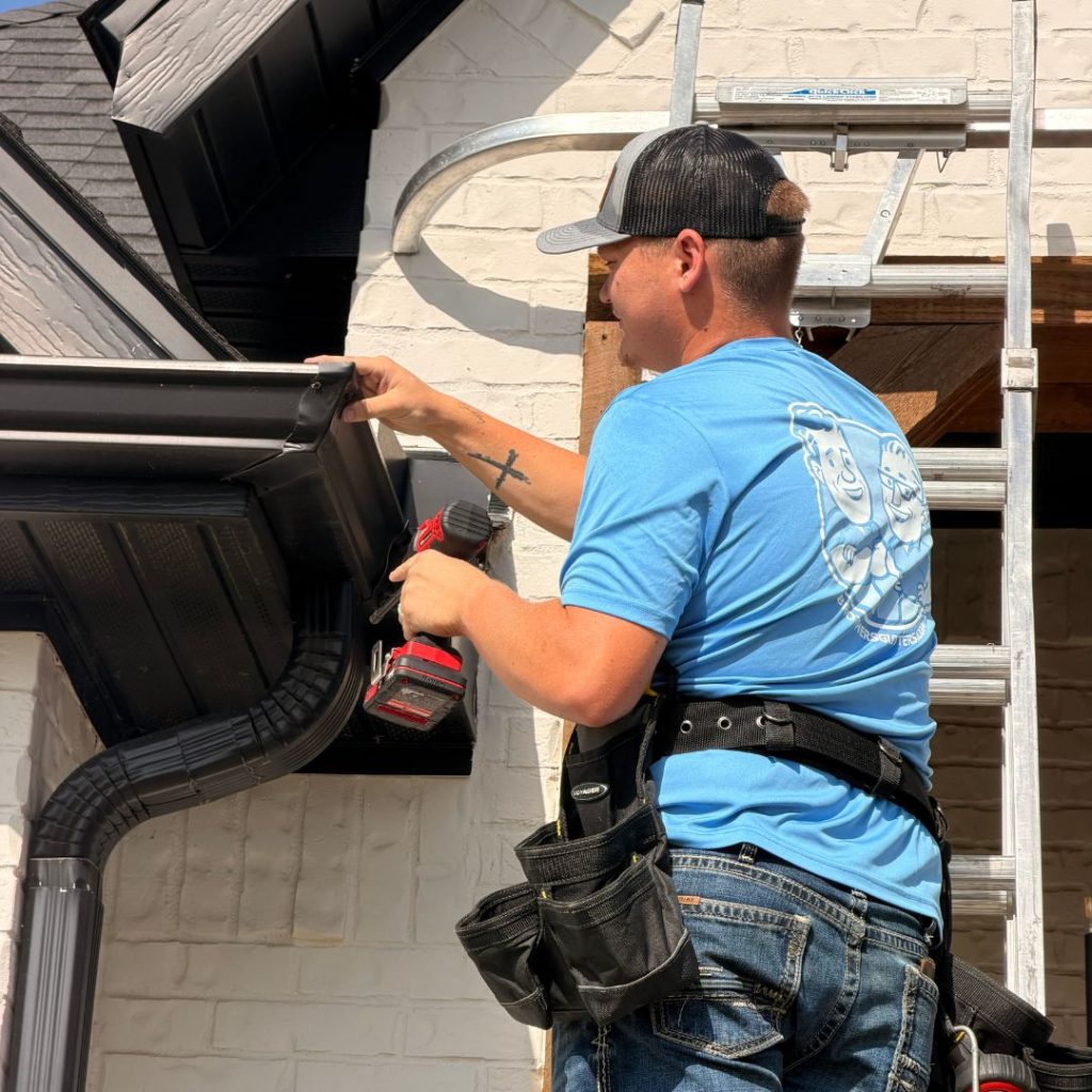 Fine metal-mesh gutter guard keeping oak leaves out on an Arkansas roofline